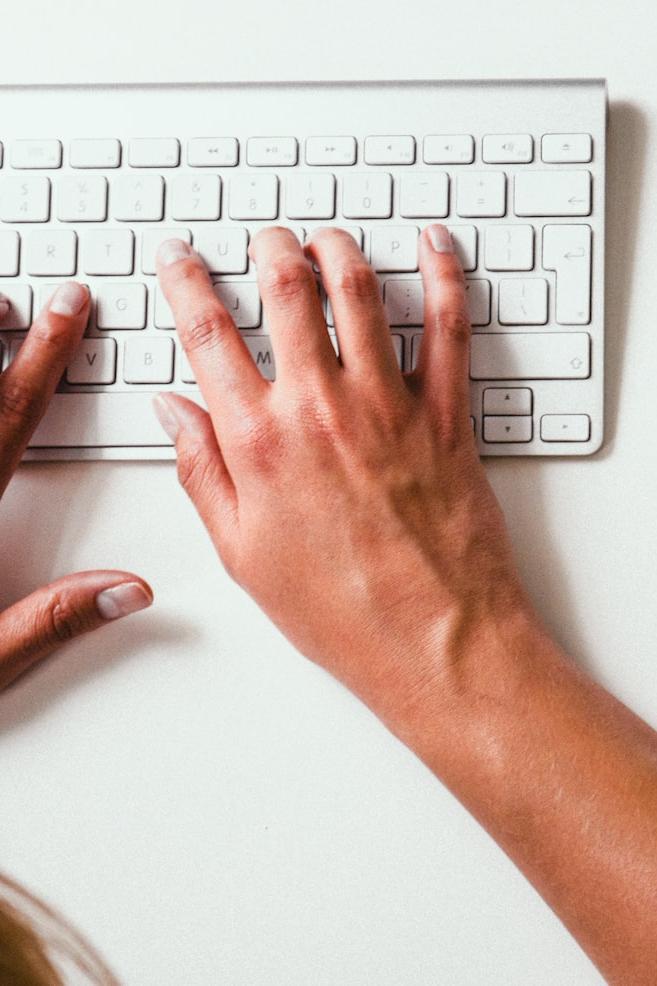 person typing on Apple Cordless Keyboard